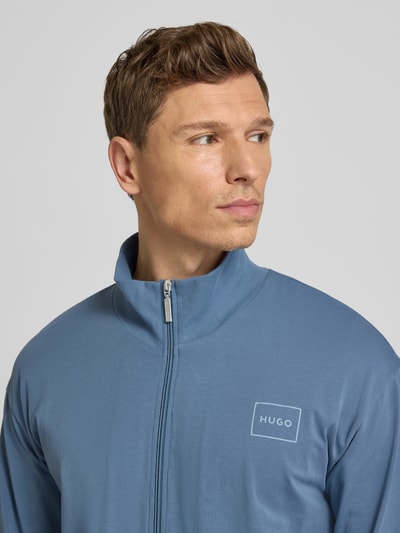 Mannelijk model draagt Regular Fit Sweatjacke uit katoenmix model 'LAZE ZIP' van HUGO in effen blauw met label patch, Nahaufnahme Oberkörper.