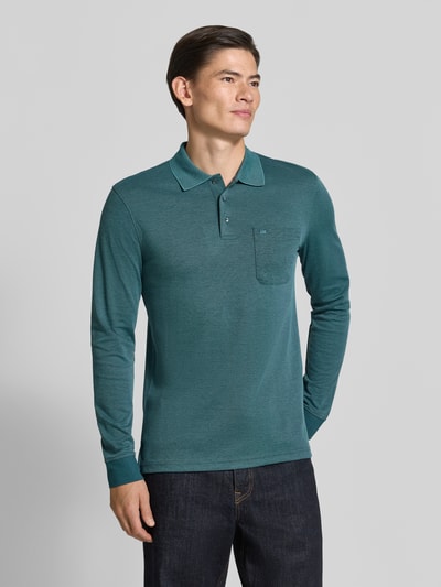 Męski model nosi Regular Fit Poloshirt mit Baumwoll-Anteil von Christian Berg Men, Mieszanka materiałów, kołnierzyk polo, kieszeń na piersi, z długim rękawem, długość tyłu w rozmiarze M: 70 cm, widok całej sylwetki z przodu