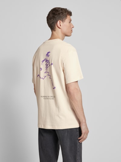 Männermodel trägt Relaxed Fit T-Shirt aus reiner Bio-Baumwolle Modell 'MAARKOS' von Armedangels in Unifarbe mit Logo Print, Rückansicht.