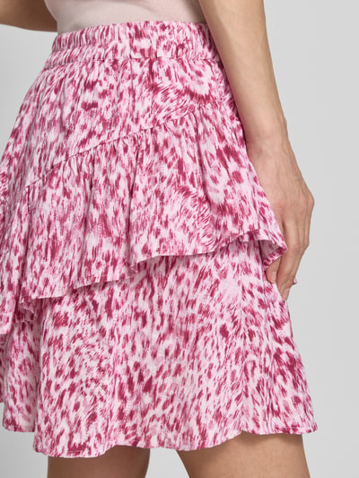 Vrouwenmodel draagt minirok met volantzoom model 'Vildea' van mbyM in roze-wit print, puur katoen, A-lijn, elastische band, detailopname heup