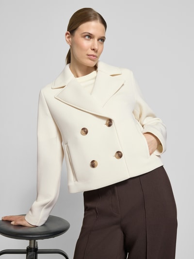 Frauenmodel trägt Regular Fit Jacke mit Viskose-Anteil von Christian Berg Woman Selection, cremefarben, doppelte Knopfleiste, Reverskragen, Eingrifftaschen, Elastischer-Material-Mix, Ganzkörperansicht von vorne.