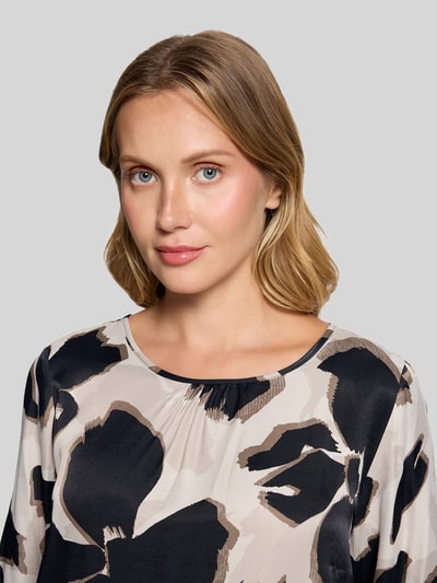 Kobiece modelka nosi bluzkę z długim rękawem Loose Fit Langarmbluse aus reiner Viskose model 'NOS JULI' od Betty Barclay, wzór w czarno-beżowe plamy, miękka tekstura materiału, kontekst: damska bluzka z długim rękawem od Betty Barclay, zbliżenie na górną część ciała.