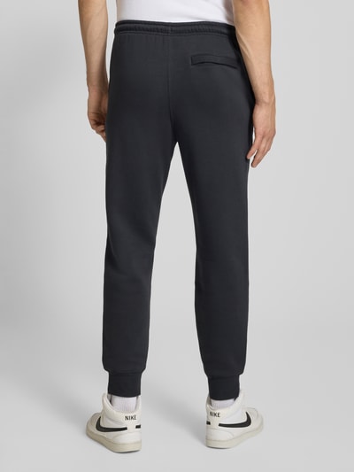 Männermodel trägt Sweatpants mit Label-Stitching und Gesäßtasche von Nike aus Baumwoll-Mix in Regular-Fit, Ganzkörperansicht Rückansicht.