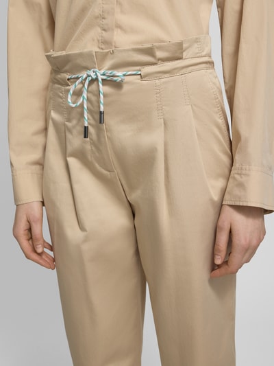 Vrouwenmodel draagt Straight Fit stoffen broek met tunnelkoord van Marc Cain, katoenmix, plooien, deels elastische band, detailopname taille.