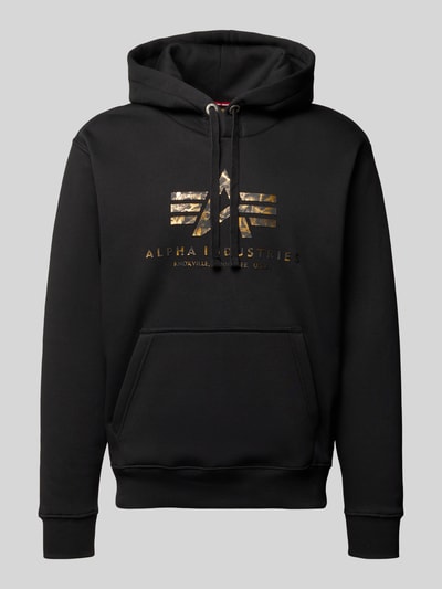 Produktfoto, Hoodie mit Logo und Känguru-Tasche von Alpha Industries aus schwarzem Baumwoll-Mix, Regular-Fit, glatte Struktur, goldenes Logo.