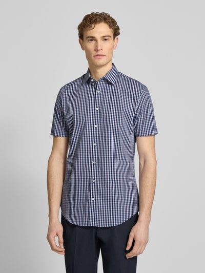 Männermodel trägt Slim Fit Business-Hemd aus katoen met kentkraag van Jake*s, ruitpatroon, knoopsluiting, 1/2-mouwen, puur katoen. Ganzkörperansicht von vorne.