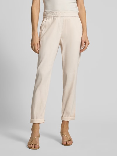 Frauenmodel trägt Straight Fit Leinenhose mit Viskose-Anteil von Marc Cain in hellem Beige, elastischer Bund, Gesäßtaschen, Nahaufnahme Oberkörper.