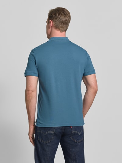 Männermodel trägt Regular Fit Poloshirt aus reiner Baumwolle von Tom Tailor, efekt: jednolity kolor, krój regular fit, wyhaftowane logo, kołnierzyk polo, zapięcie na 2 guziki, krótki rękaw, wykończenie z rozcięciami po bokach, wykończenie materiału: pika, 100% bawełna, Ganzkörperansicht Rückansicht.