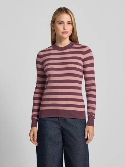 Frauenmodel trägt Strickpullover mit Rundhalsausschnitt von Christian Berg Woman, gestreiftes Muster in Beere und Rosa, Viskose-Mix, taillierter Schnitt, gerippte Abschlüsse, Ganzkörperansicht von vorne.