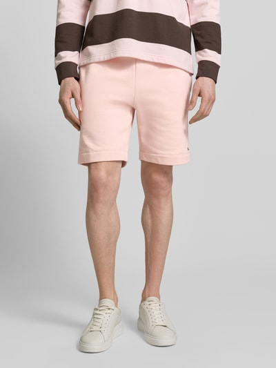 Mannelijk model draagt Regular Fit Sweatshorts aus Baumwoll-Mix van Lacoste in effen kleuren, katoenmix sweat, labelpatch, steekzakken, elastisch boord met tunnelkoord, achterzak. Ganzkörperansicht van voren.