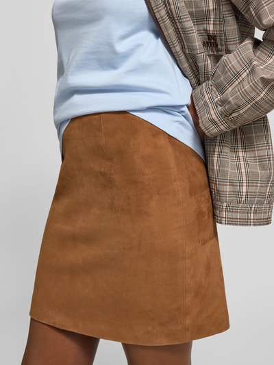 Frauenmodel trägt Minirock aus echtem Ziegenvelours von ROTATE, Suede-Optik, Slim Fit, Strukturmuster, Nahtreißverschluss, Nahaufnahme Oberkörper.