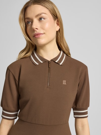 Vrouwenmodel draagt Minikleid mit Polokragen und Logo-Stitching van ARMANI EXCHANGE in bruin met witte strepen, viscosemix, getailleerde fit, korte rits, logo-stiksel, detailopname bovenlichaam.