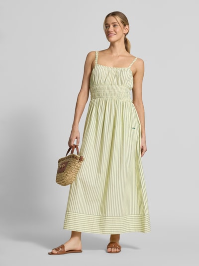 Frauenmodel trägt Regular Fit Freizeitkleid aus reiner Baumwolle von BOSS Orange, Optik:Allover-Muster, gestreift, Midi-Länge, Spaghettiträger, feine Streifen in Beige und Gelb, glatte Baumwolltextur, Ganzkörperansicht von vorne.