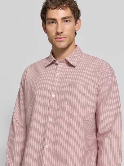 Männermodel trägt Relaxed Fit Freizeithemd aus reiner Baumwolle von Jake*s Studio Men, rosa mit feinen Streifen, Nahaufnahme Oberkörper.