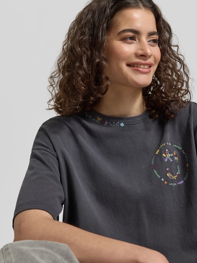 Frauenmodel trägt Relaxed Fit T-Shirt mit floralem Stitching von JAKE*S STUDIO WOMAN in Dunkelgrau, Rundhalsausschnitt, Nahaufnahme Oberkörper.
