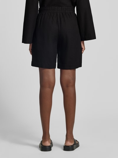 Frauenmodel trägt schwarze Leinenshorts mit elastischem Bund Modell 'Lava' von FREE/QUENT, lockerer Schnitt, Leinen-Mix, Ganzkörperansicht Rückansicht.