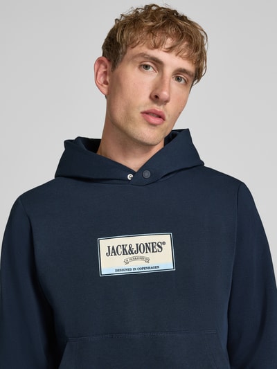 Männermodel trägt Hoodie mit Label-Print Modell 'FREDERIKSBERG' von JACK & JONES, dunkelblau, Baumwoll-Mix, Nahaufnahme Oberkörper.