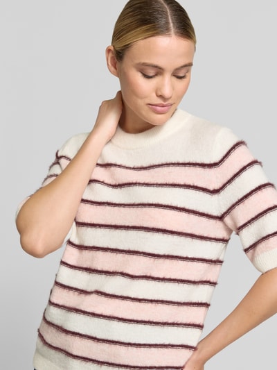Frauenmodel trägt Loose Fit Pullover mit Mohair-Woll-Anteil Modell 'Pimota Stripe' von OPUS, gestricktes Allover-Streifenmuster in Creme, Rosa und Braun, gerippter Rumpfabschluss, Rundhals, kurzarm, Nahaufnahme Oberkörper.