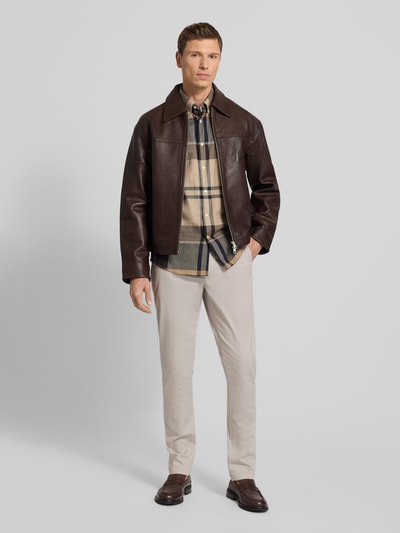 Männermodel trägt Regular Fit Chino aus Baumwoll-Mix Modell 'DENTON' von Tommy Hilfiger, Optik: Allover-Muster, Ganzkörperansicht von vorne.