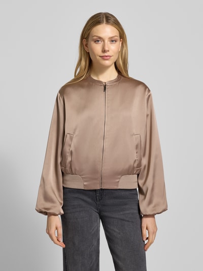 Frauenmodel trägt Blouson mit Reißverschluss Modell 'Jupita' von OPUS in Beige, glatte Textur, seitliche Eingrifftaschen, Ganzkörperansicht von vorne.