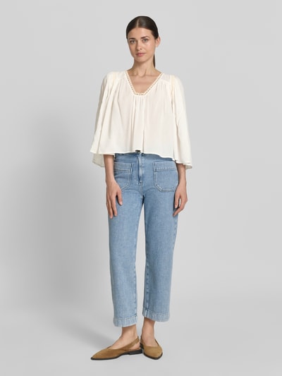 Frauenmodel trägt Cropped Bluse mit 3/4-Arm Modell 'ISMARA' von Drykorn aus Baumwoll-Viskose-Mix in Creme, Ganzkörperansicht von vorne.