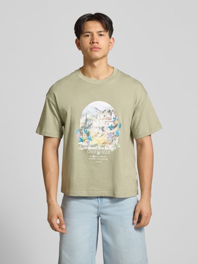 Männermodel trägt T-Shirt mit Rundhalsausschnitt von Jack & Jones aus Reine Baumwolle mit Print, Regular-Fit, helle Farben, Ganzkörperansicht von vorne. Rückenlänge bei Größe M: 70 cm