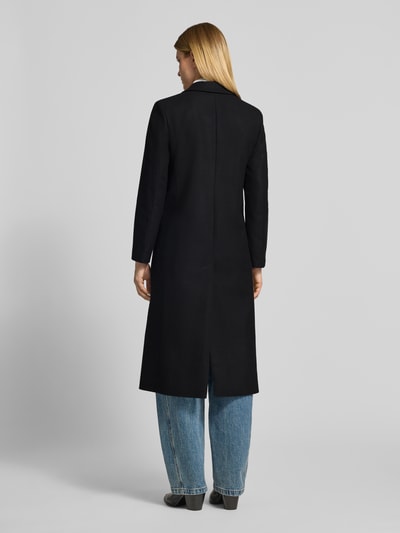 Frauenmodel trägt Relaxed Fit Mantel aus Woll-Mix Modell 'Mojeni' von HUGO in Schwarz, kombiniert mit blauen Jeans, Damen Mantel von HUGO, Ganzkörperansicht Rückansicht.