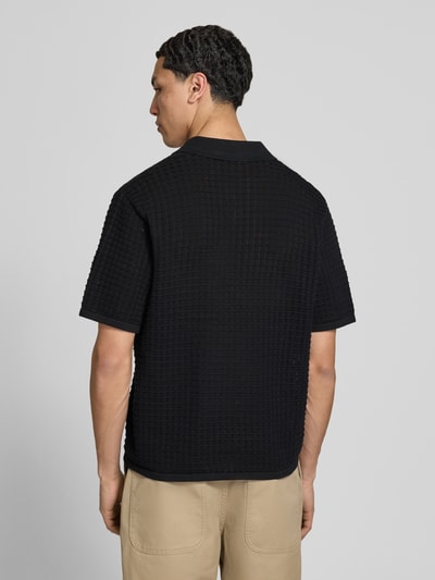 Męski model nosi Regular Fit Poloshirt mit V-Ausschnitt von Jack & Jones z bawełny, czarny, krój regular fit, długość tyłu 67 cm, Ganzkörperansicht Rückansicht.