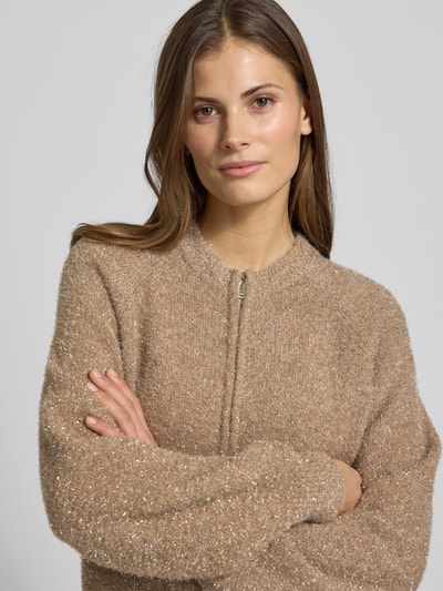 Frauenmodel trägt Strickjacke mit Zweiwege-Reißverschluss Modell 'Dosmic' von OPUS, in Beige-Ton, Material-Mix mit Stretch-Anteil, Regular-Fit, Nahaufnahme Oberkörper.