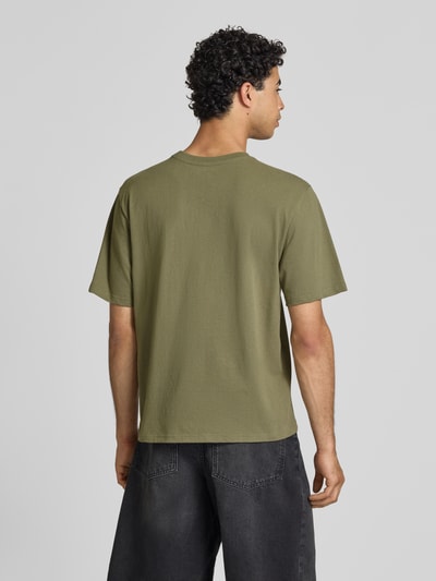 Männermodel trägt T-Shirt mit Label-Patch und Rundhalsausschnitt von REVIEW in Grün, Boxy-Fit, Reine Baumwolle, Rückenlänge 66 cm bei Größe M, Ganzkörperansicht Rückansicht