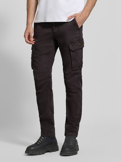 Männermodel trägt Cargohose mit Pattentaschen Modell 'EXPEDIZOR' von PME Legend in dunklem Braun, Skinny Fit, Ganzkörperansicht von vorne.