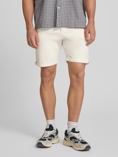 Männermodel trägt Jeansshorts mit Umschlag und Eingrifftaschen Modell 'RICK ALLEN' von Jack & Jones im Baumwoll-Elasthan-Mix, Regular-Fit, Farbe creme, glatte Struktur, Bundweite 43 cm, Innenbeinlänge 20 cm, Nahaufnahme Oberkörper bis Knie.