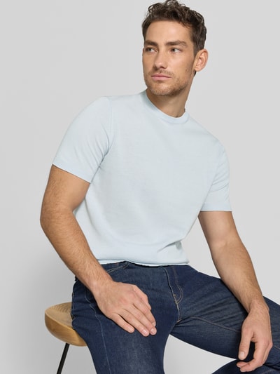 Männermodel trägt Strickshirt mit Rundhalsausschnitt von MARKUP, hellblau, glatte Textur, Regular Fit, Nahaufnahme Oberkörper.