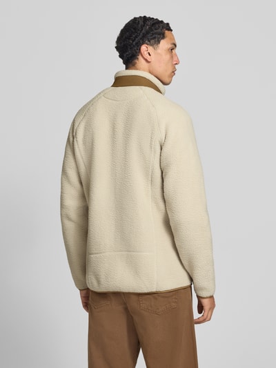 Männermodel trägt Fleecejacke mit Stehkragen von Helly Hansen in Beige, lockere Passform, elastische Abschlüsse, Ganzkörperansicht Rückansicht. Rückenlänge Größe M: 78 cm, Ärmellänge: 67 cm, mit seitlichen Eingrifftaschen und Napoleontasche.