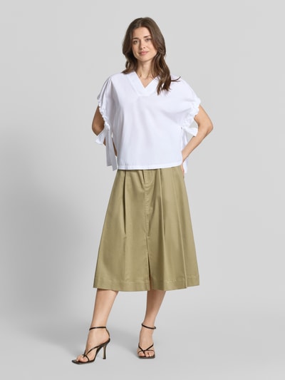 Frauenmodel trägt Relaxed Fit Bluse mit V-Ausschnitt von Marc Cain in Weiß aus Reine Baumwolle, Kurzärmelig, Raffung, Ganzkörperansicht von vorne.