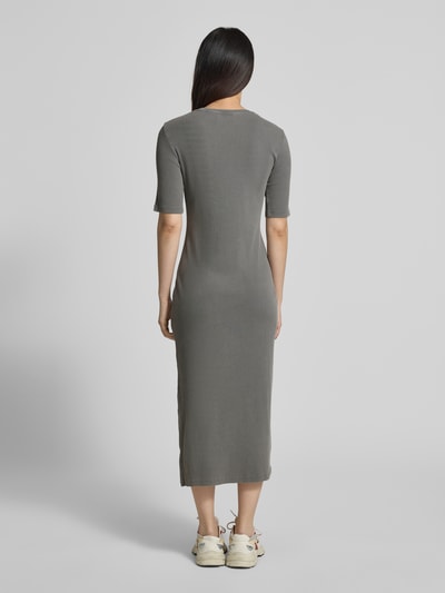 Frauenmodel trägt körpernahes Freizeitkleid aus Baumwoll-Mix Modell 'SEHAARAA' von Armedangels in Grau mit Used-Look, Midi-Länge, Seitenschlitz, Label-Stitching-Applikation, Ripp-Material, Kurzarm, Rundhals-Ausschnitt, Ganzkörperansicht Rückansicht.