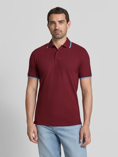 Männermodel trägt Slim Fit Poloshirt aus Baumwoll-Mix Modell 'ATLAS' von Selected Homme in Bordeaux mit blauen Akzenten, Herren Poloshirt, Ganzkörperansicht von vorne.