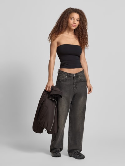 Frauenmodel trägt Schmal geschnittenes Bandeau-Top von REVIEW in Schwarz, elastisches Baumwoll-Elasthan-Material, Off-Shoulder-Look, Slim Fit, Ganzkörperansicht von vorne.