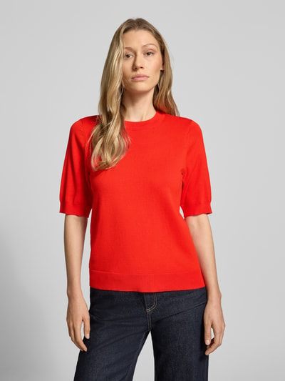 Frauenmodel trägt Strickshirt aus Viskose-Mix mit Rundhalsausschnitt Modell 'LENA' von YAS, Körpernaher-Schnitt, leuchtend rot, glatte Textur, 1/2-Arm, gerippte-Abschlüsse, Rückenlänge bei Größe S 54 cm, Ärmellänge 29 cm, Ganzkörperansicht von vorne.