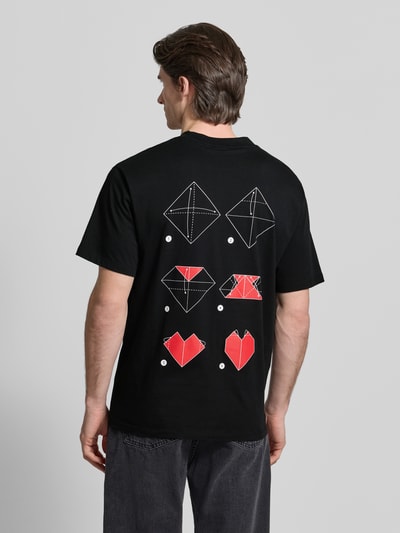Männermodel trägt schwarzes Regular Fit T-Shirt aus reiner Baumwolle Modell 'DALENTIN' von HUGO mit Motiv-Print, Ganzkörperansicht Rückansicht.