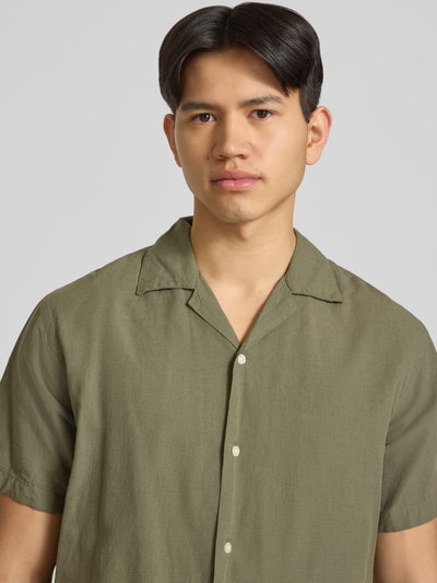 Männermodel trägt Regular Fit Freizeithemd aus Baumwoll-Leinen-Mix von Jack & Jones in Oliv mit Reverskragen, Nahaufnahme Oberkörper. Modell 'BREEZE', Knopfleiste, Rückenlänge 71 cm, Schulterbreite 50 cm, Ärmellänge 26 cm.