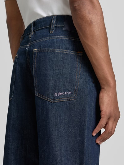 Männermodel trägt Wide Fit Jeans aus reiner Baumwolle von Paul Smith, dunkelblau, sichtbare Nähte, 5-Pocket-Design, Nahaufnahme Oberkörper, Kontext: Herren Jeans von Paul Smith, reine Baumwolle, Wide Fit, 5-Pocket-Design, Gürtelschlaufen, Knopf- und Reißverschluss, Bundweite bei Größe 32: 44 cm, Innenbeinlänge bei Größe 32: 79 cm