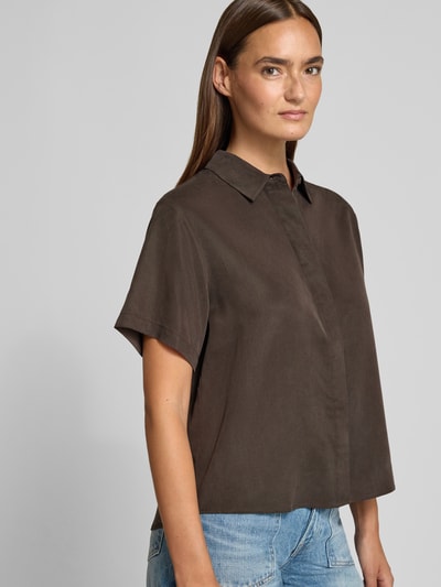 Frauenmodel trägt Regular Fit Hemdbluse mit 1/2-Arm Modell 'MINA' von Samsøe Samsøe aus Lyocell, Kentkragen, verdeckte Knopfleiste, Rückenlänge 59 cm, Ärmellänge 21 cm, Dunkelbraun, glatte Struktur, Ganzkörperansicht von vorne.