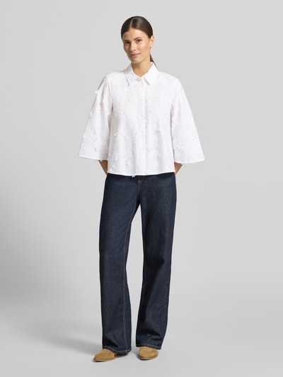 Frauenmodel trägt Regular Fit Bluse mit Stitchings Modell 'MAMICO' von EMME aus reiner Baumwolle, mit Hemdblusenkragen, Knopfleiste und 3/4-Arm, in Weiß, gerade Silhouette, strukturierte Oberfläche, Ganzkörperansicht von vorne.