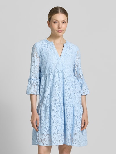 Frauenmodel trägt Loose Fit Spitzenkleid aus Baumwoll-Mix Modell 'HONEY' von Vero Moda in Hellblau, Spitzen-Muster, knielang, V-Ausschnitt, 3/4-Arm mit Glockenärmel, Optik: Unifarben, Materialverarbeitung: Spitze, Nahaufnahme Oberkörper.