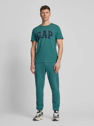 Männermodel trägt T-Shirt mit Logo und Rundhalsausschnitt von GAP, Herren T-Shirt, Reine Baumwolle, Regular-Fit, Logo, Rückenlänge 72 cm, Ganzkörperansicht von vorne.