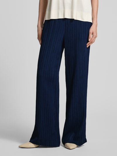 Frauenmodel trägt Hose mit Strukturmuster Modell 'Grsvalse' von FREE/QUENT in Dunkelblau, Material-Mix, weites Bein, Nahaufnahme Unterkörper.