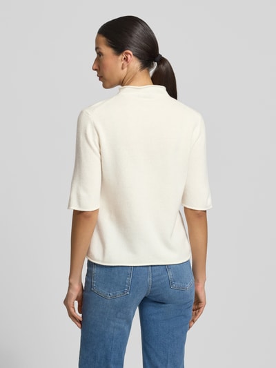 Vrouwenmodel draagt gebreid shirt van zuiver wol met opstaande kraag en rolzoom, model 'Tumea' van Someday, regular fit, ruglengte maat 36: 52 cm, mouwlengte maat 36: 34 cm, kleur crème, zachte textuur, rugaanzicht, geheel lichaam.