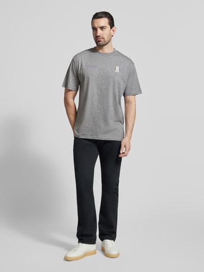 Männermodel trägt Relaxed Fit T-Shirt aus reiner Bio-Baumwolle Modell 'MAARKOS' von Armedangels, unifarben, Logoprint, Ganzkörperansicht von vorne