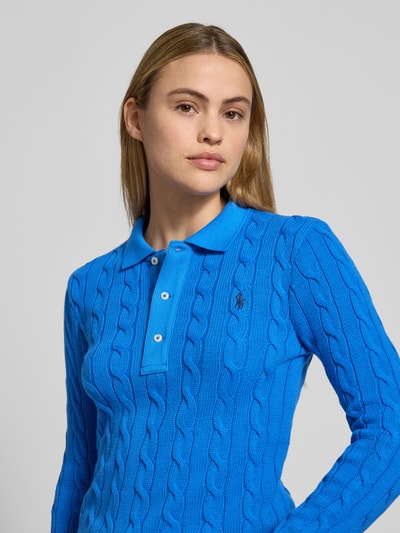 Frauenmodel trägt Strickpullover mit Zopfmuster und Polokragen von Polo Ralph Lauren in Blau, reine Baumwolle, Nahaufnahme Oberkörper.